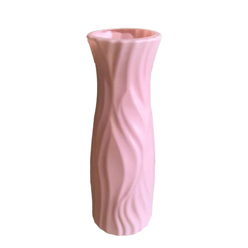 Pink ceramic vase with wavy texture on a white background