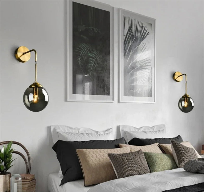 Modern bedroom with a bed, wall sconces, and framed artwork.