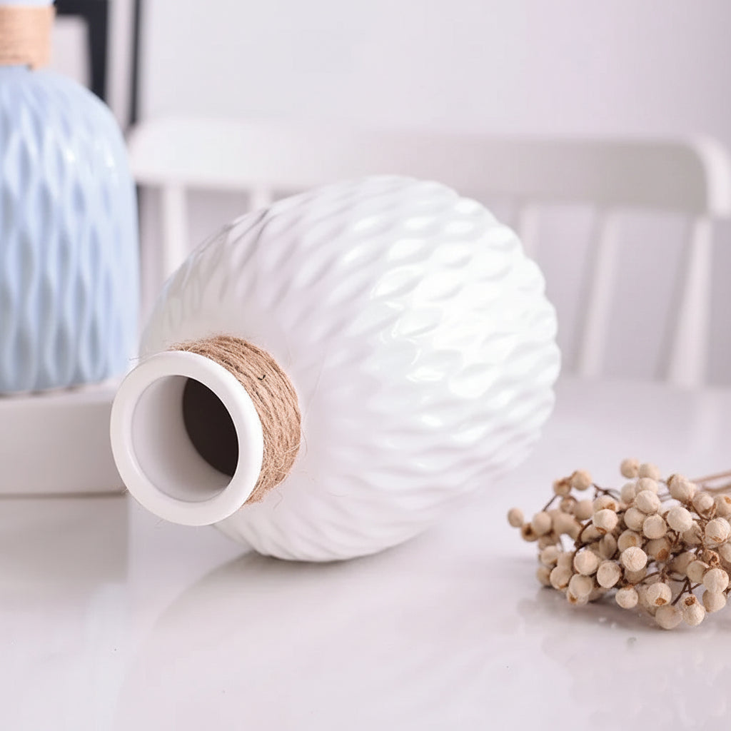 White ceramic vase with textured design on a light background