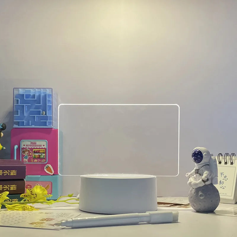 Desk setup with a white rectangular object, books, and a small figurine on a light gray surface.