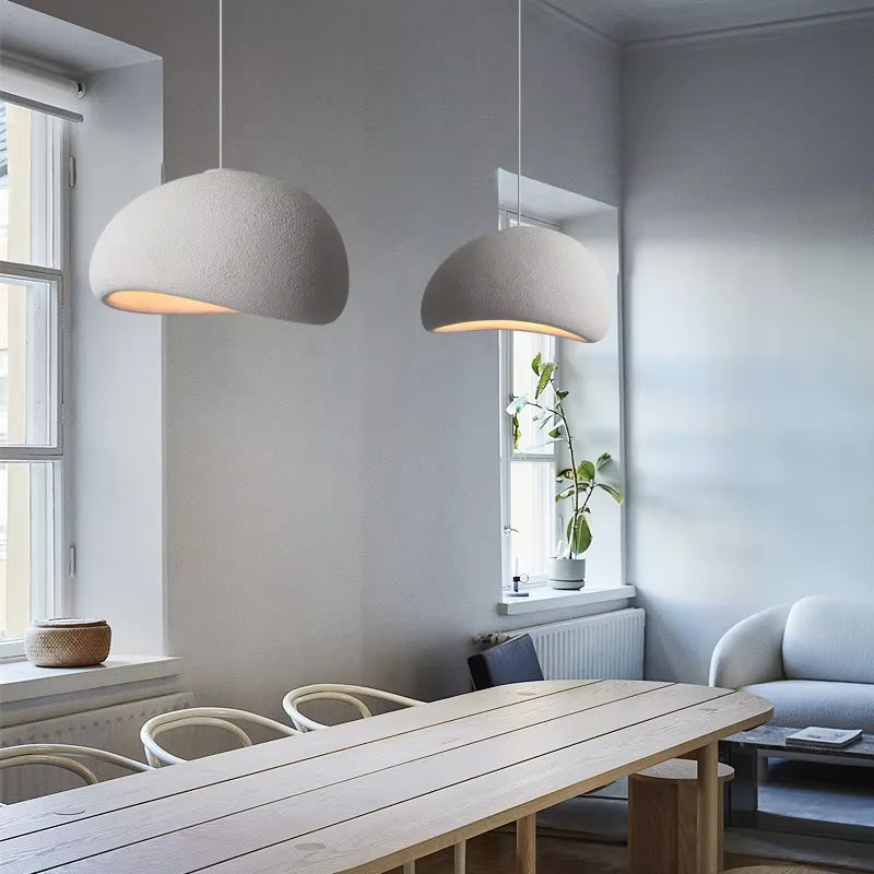Modern interior with pendant lights, wooden table, and white walls.