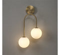 Wall-mounted light fixture with two round glass shades on a gray background