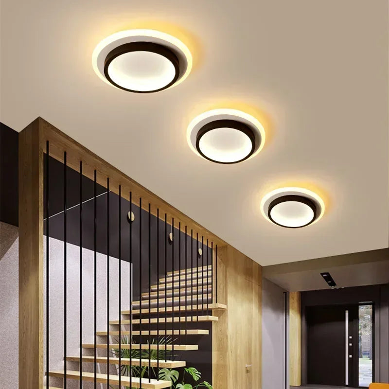 Modern ceiling lights in a home interior setting with stairs and wall decor.