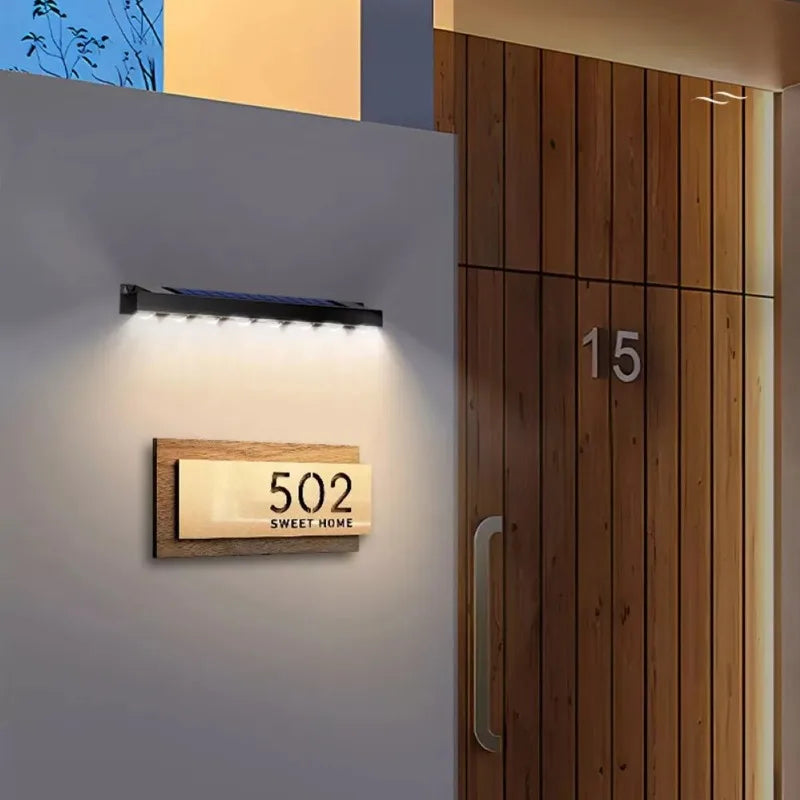 House number 502 on a wooden door with a light fixture on the wall.