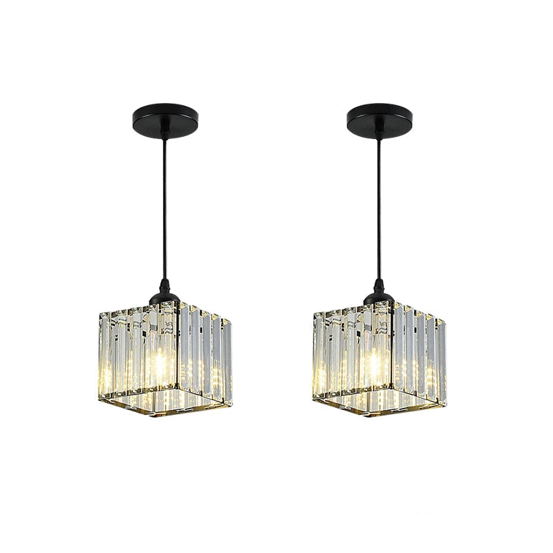 Two modern pendant light fixtures with clear rectangular crystal prisms and black ceiling mounts