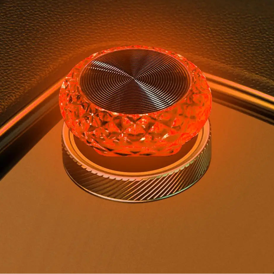 Close-up of a glowing red crystal-like object on a reflective surface