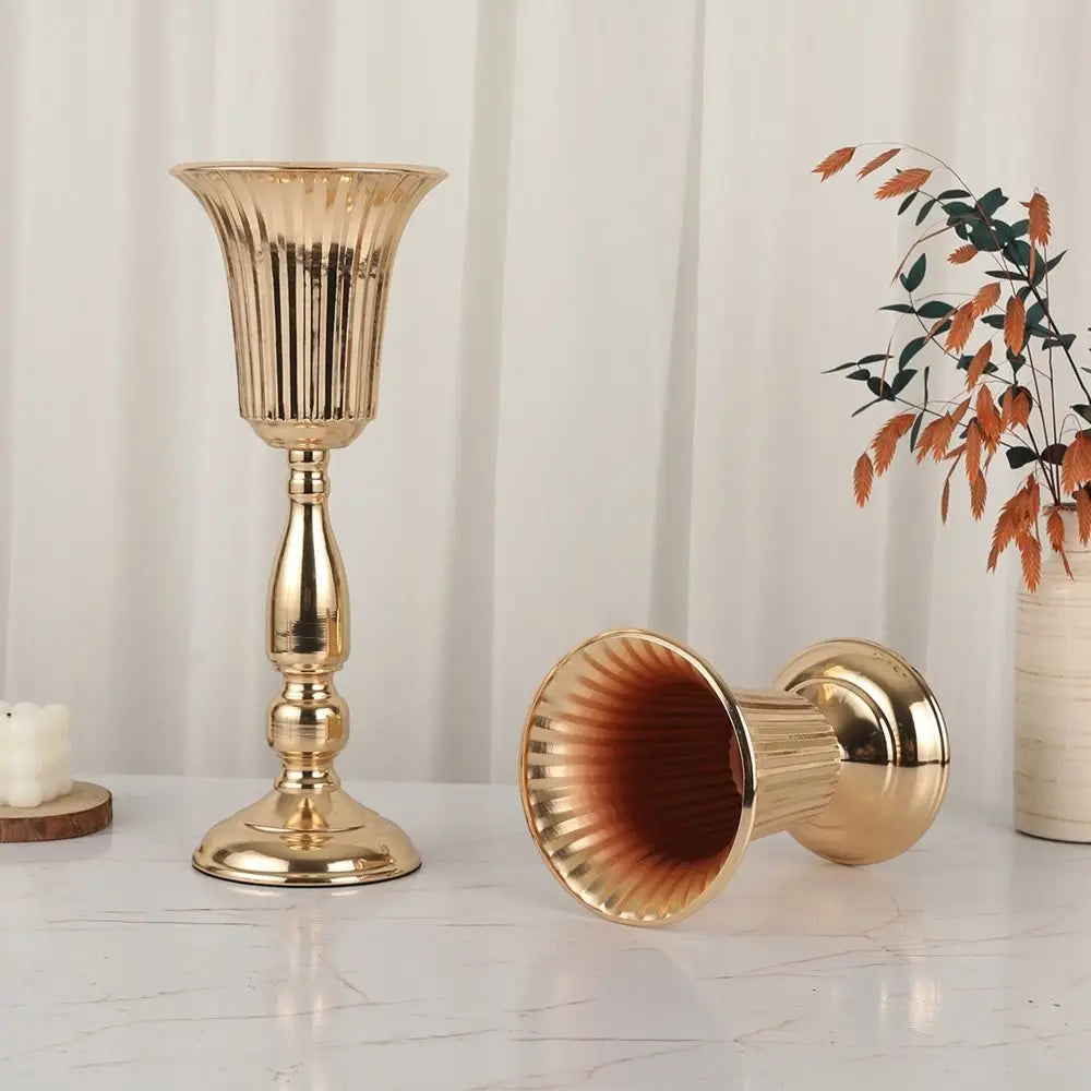 Gold candle holder and decorative item on a white surface with a neutral background