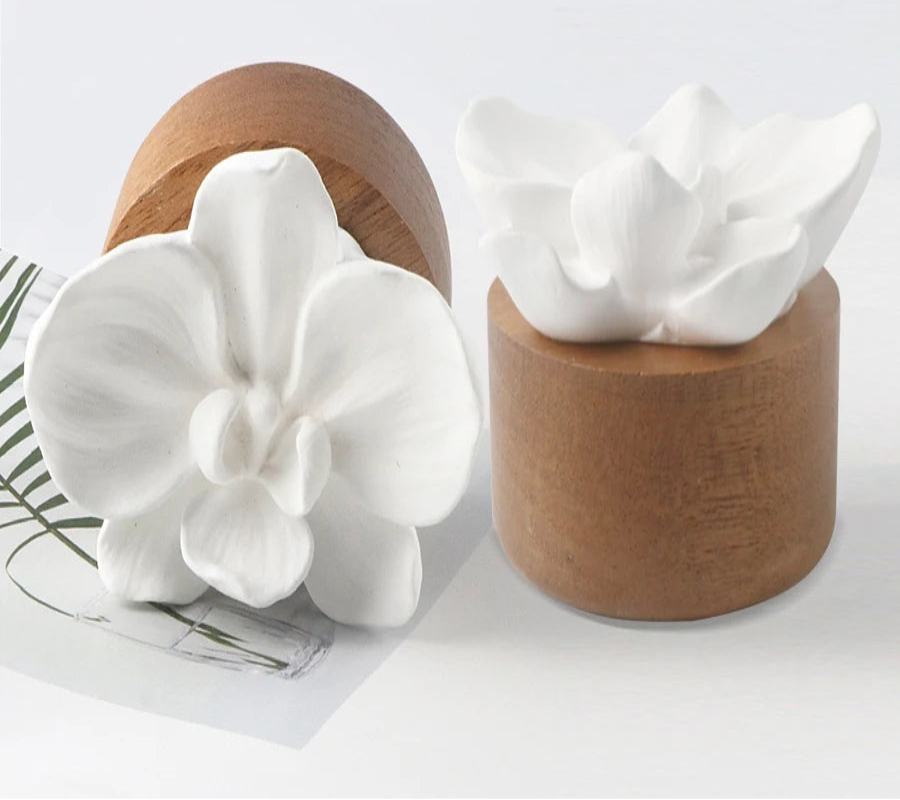 White orchid flower diffuser with wooden base on a light background