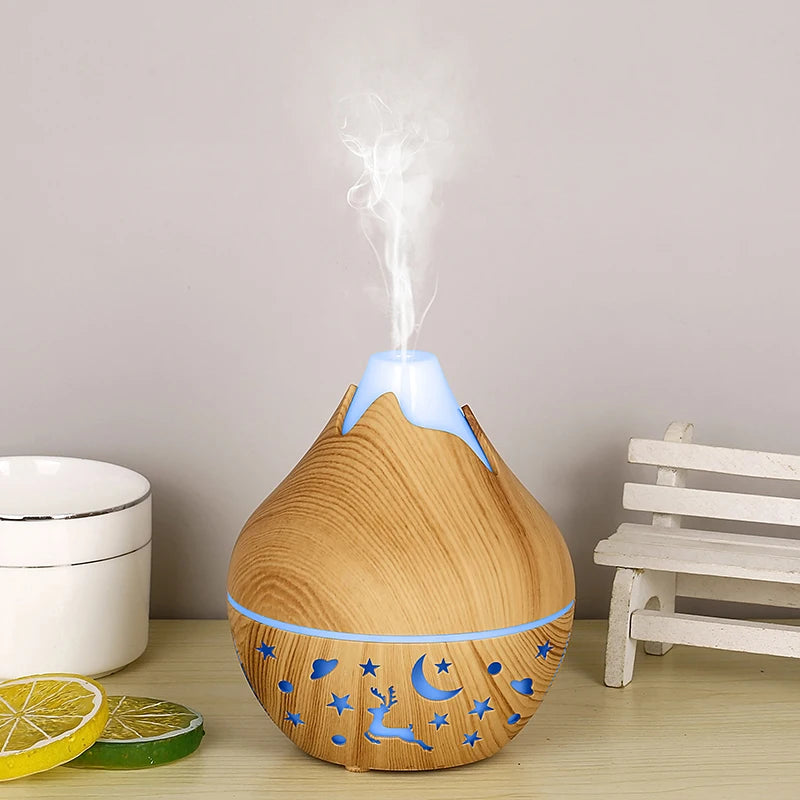 Wooden essential oil diffuser emitting mist on a wooden surface with a neutral background