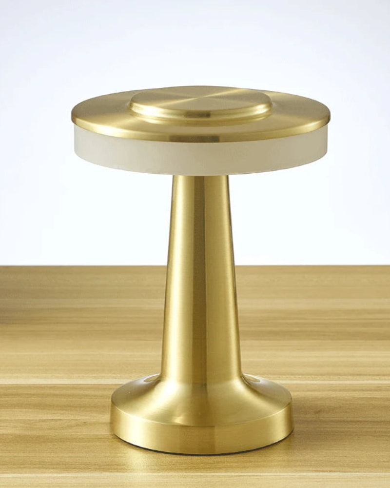 Gold and white cylindrical object on a wooden surface with a blurred background