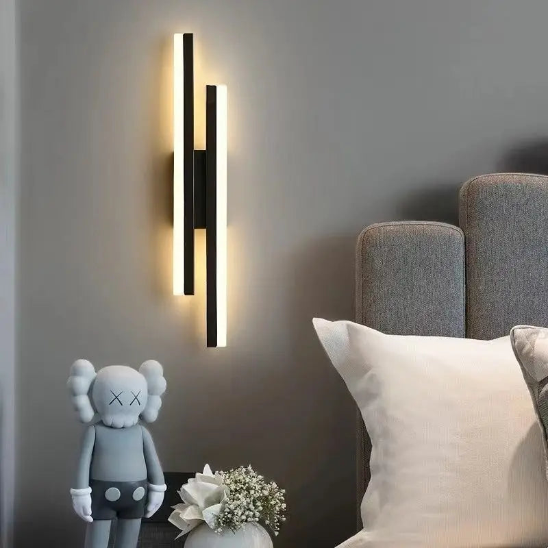 Modern wall sconce on a gray wall with decorative items below.