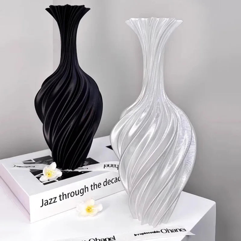 Black and white vases on a surface with a book underneath