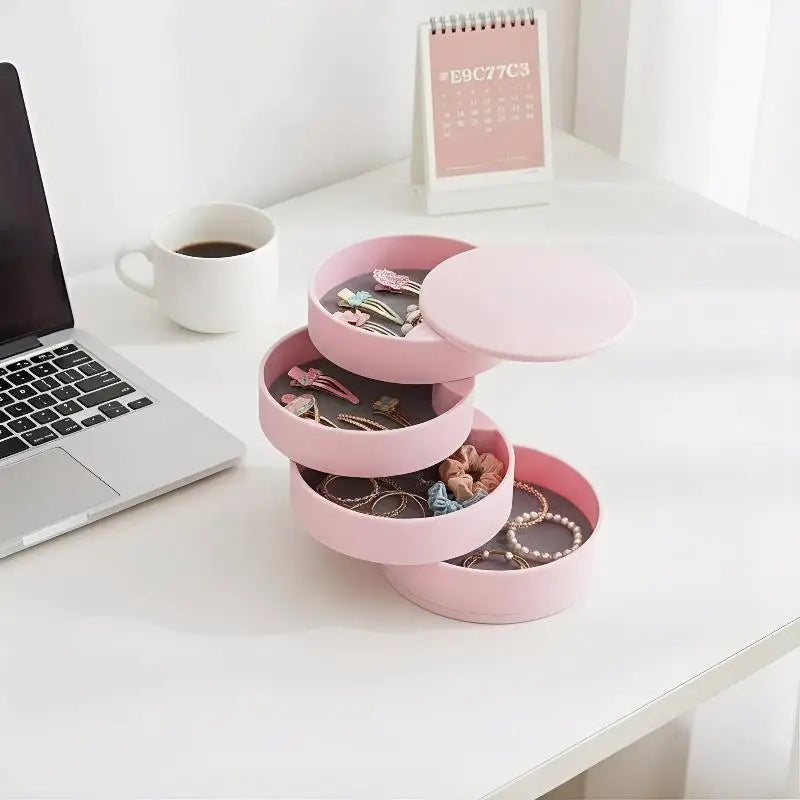 Pink jewelry organizer on a desk with a laptop and coffee cup