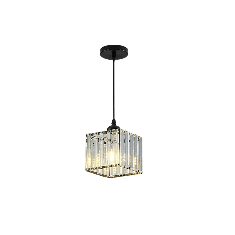 A modern square pendant light fixture with a black canopy and cord, featuring clear crystal or glass vertical bars that glow with warm light. 