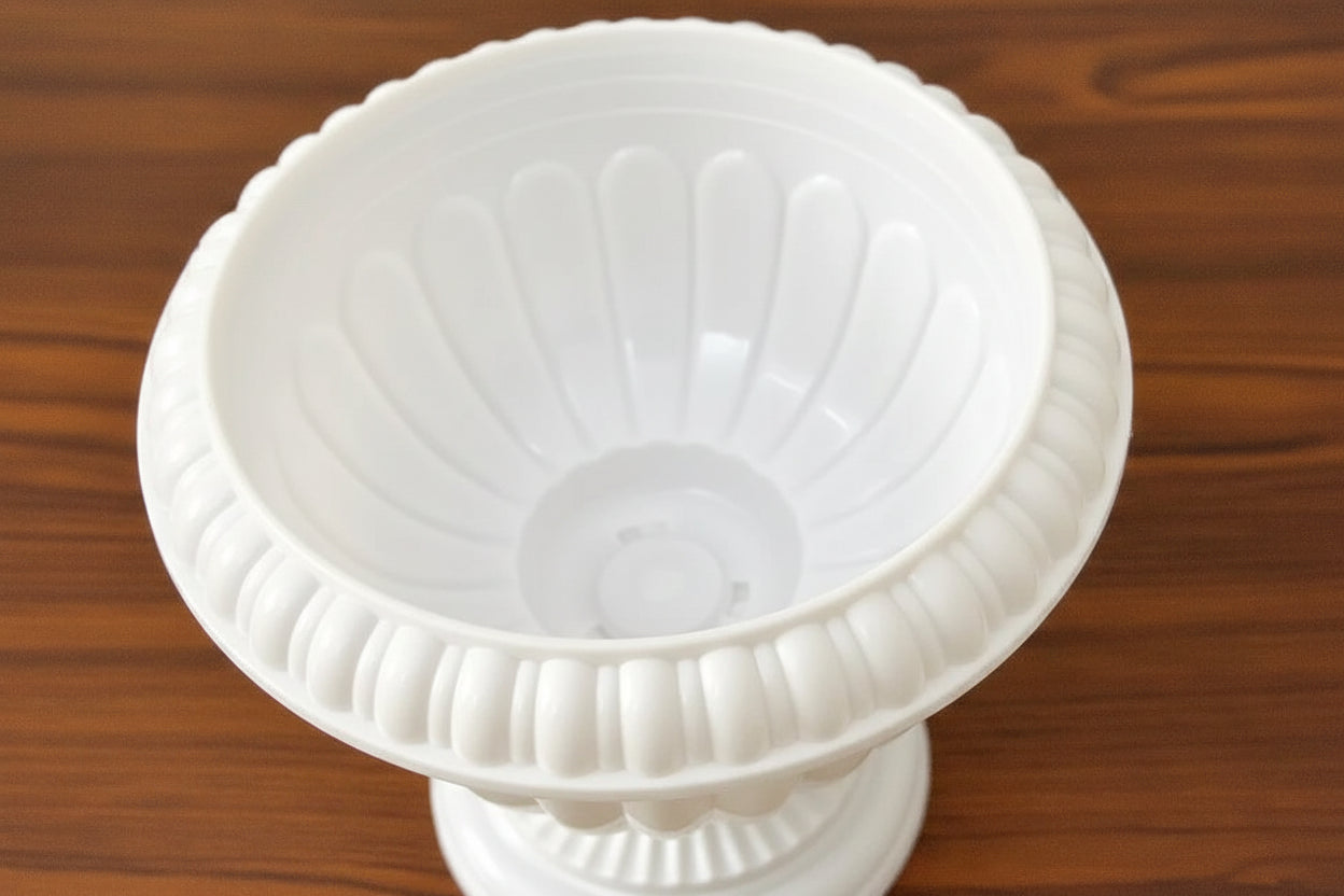 Close-up of a white plastic funnel or filter cone with flared ridges, shown on a brown wooden surface 