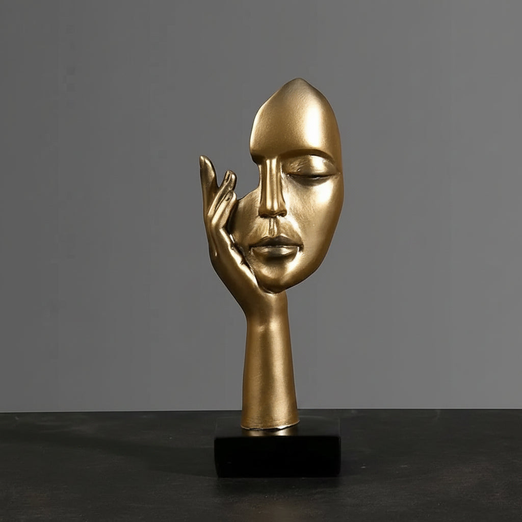 Gold abstract sculpture with dimensions on a dark surface and gray background