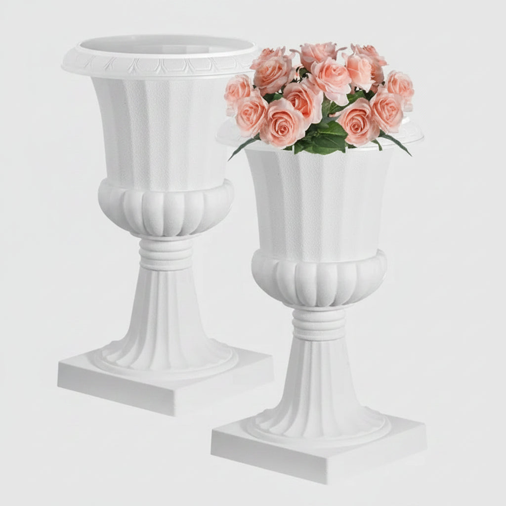 Two white faux stone pedestal planters shown on a white background, with pink roses placed in them.