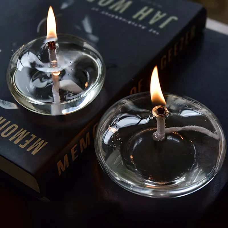 Two small candles in glass holders with a book in the background
