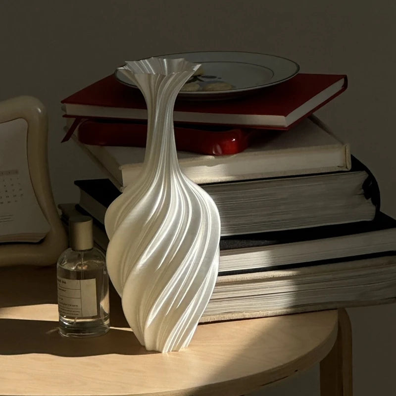 Decorative vase on a stack of books with a bottle and plate in the background