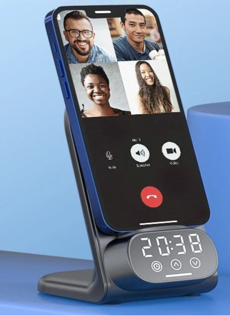 Phone charging stand with digital clock displaying time and phone screen showing multiple people.