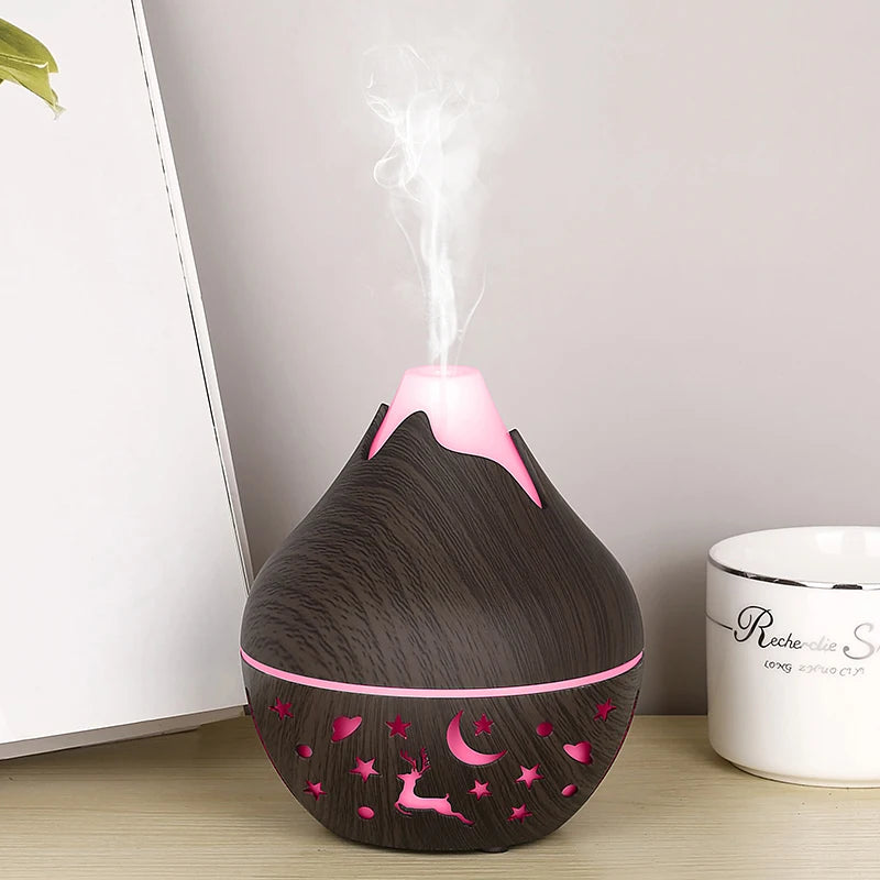 Black and pink humidifier on a wooden surface with a white wall in the background