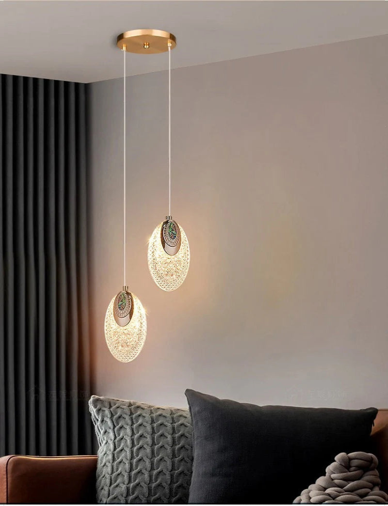 Modern pendant lights hanging in a living room setting with a sofa and cushions.