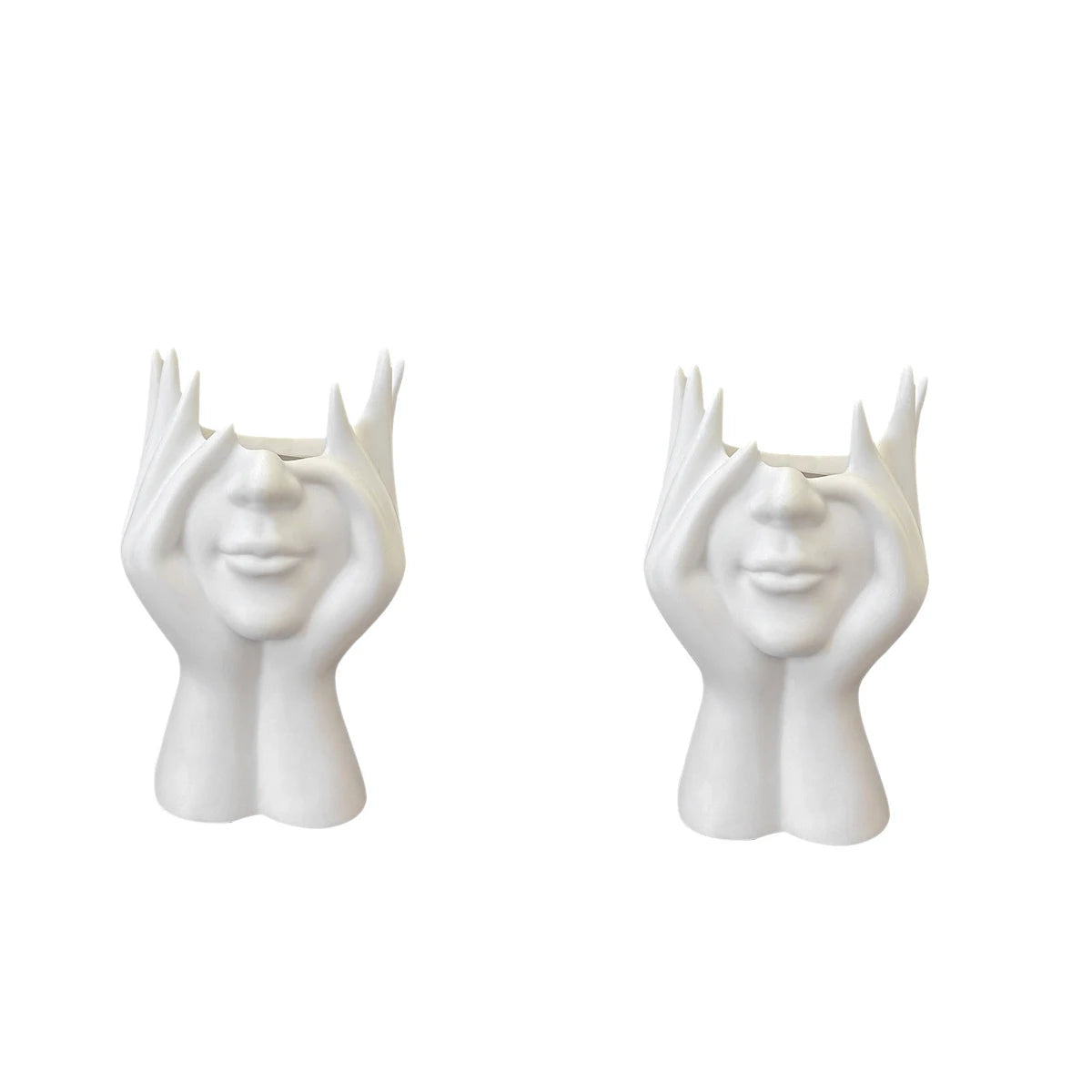 Two white ceramic face vases with hands on a white background