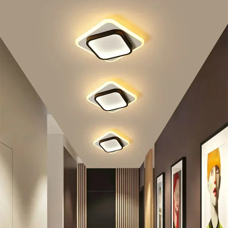 Modern ceiling lights in a hallway with framed pictures on the wall.