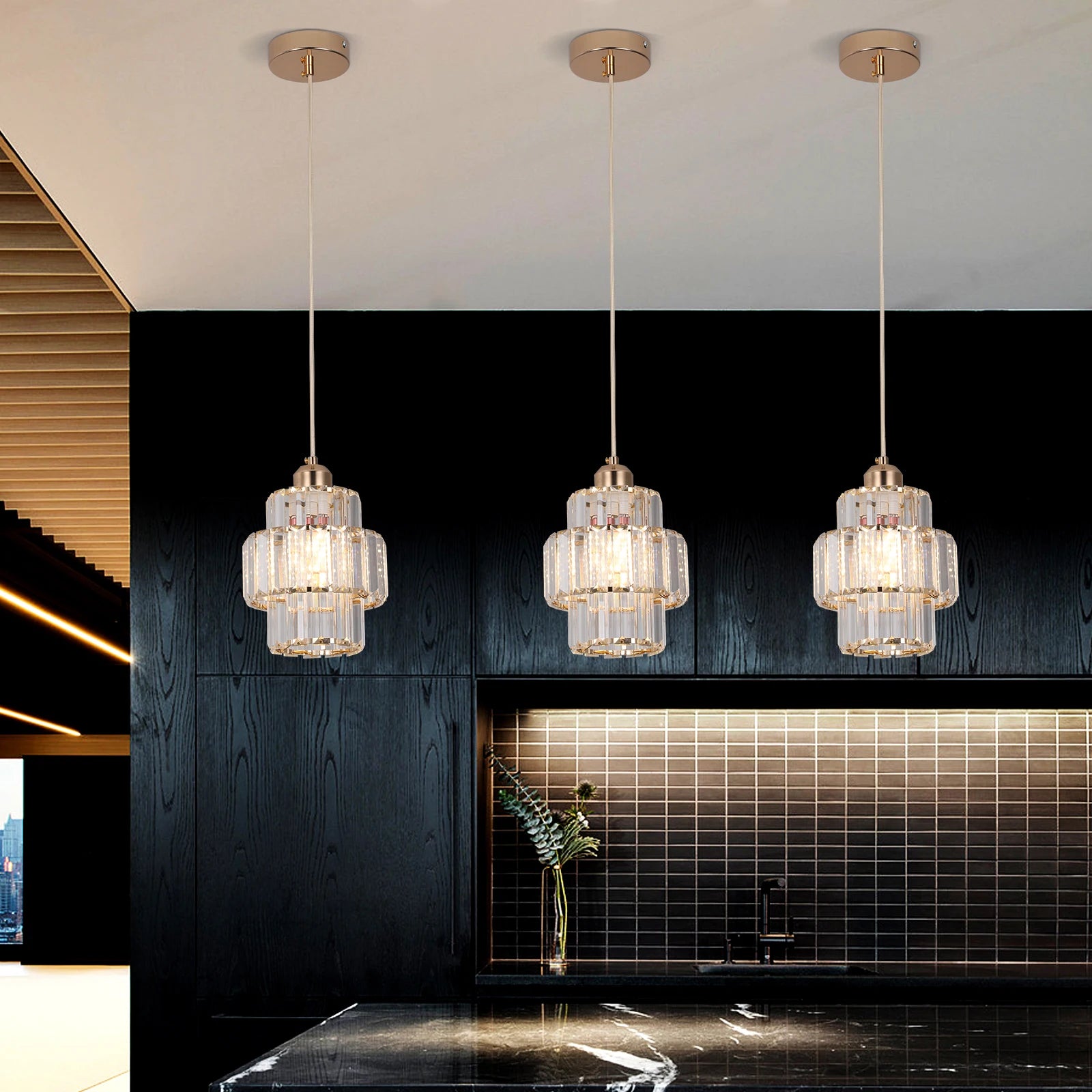 Three pendant lights hanging above a kitchen counter with a modern design.