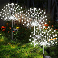 Solar garden lights shaped like dandelions in a garden setting with flowers.