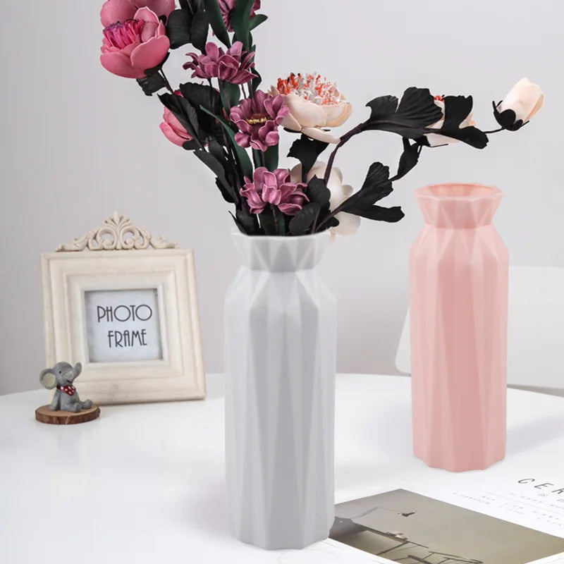 White and pink vases with floral arrangement on a white surface